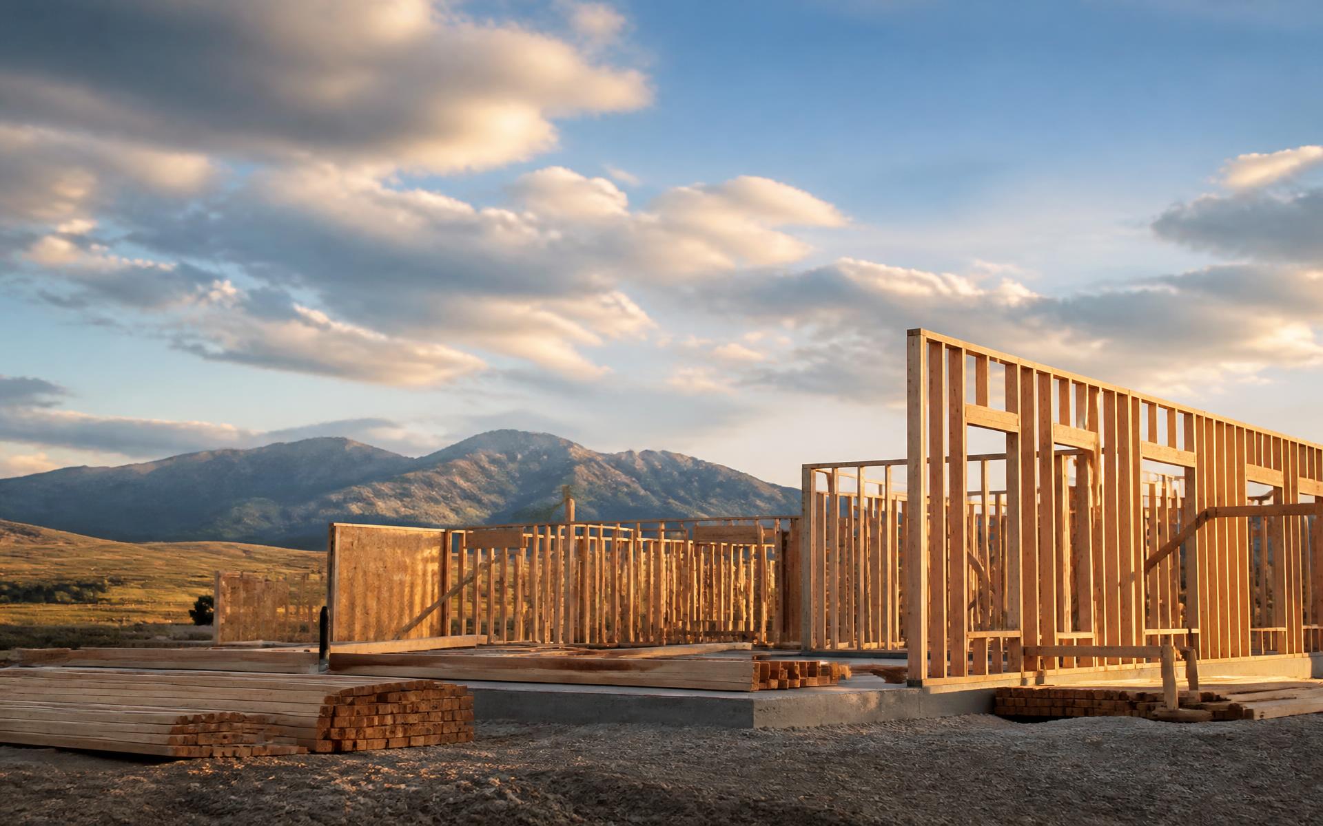Wood-framed home under construction at sunset