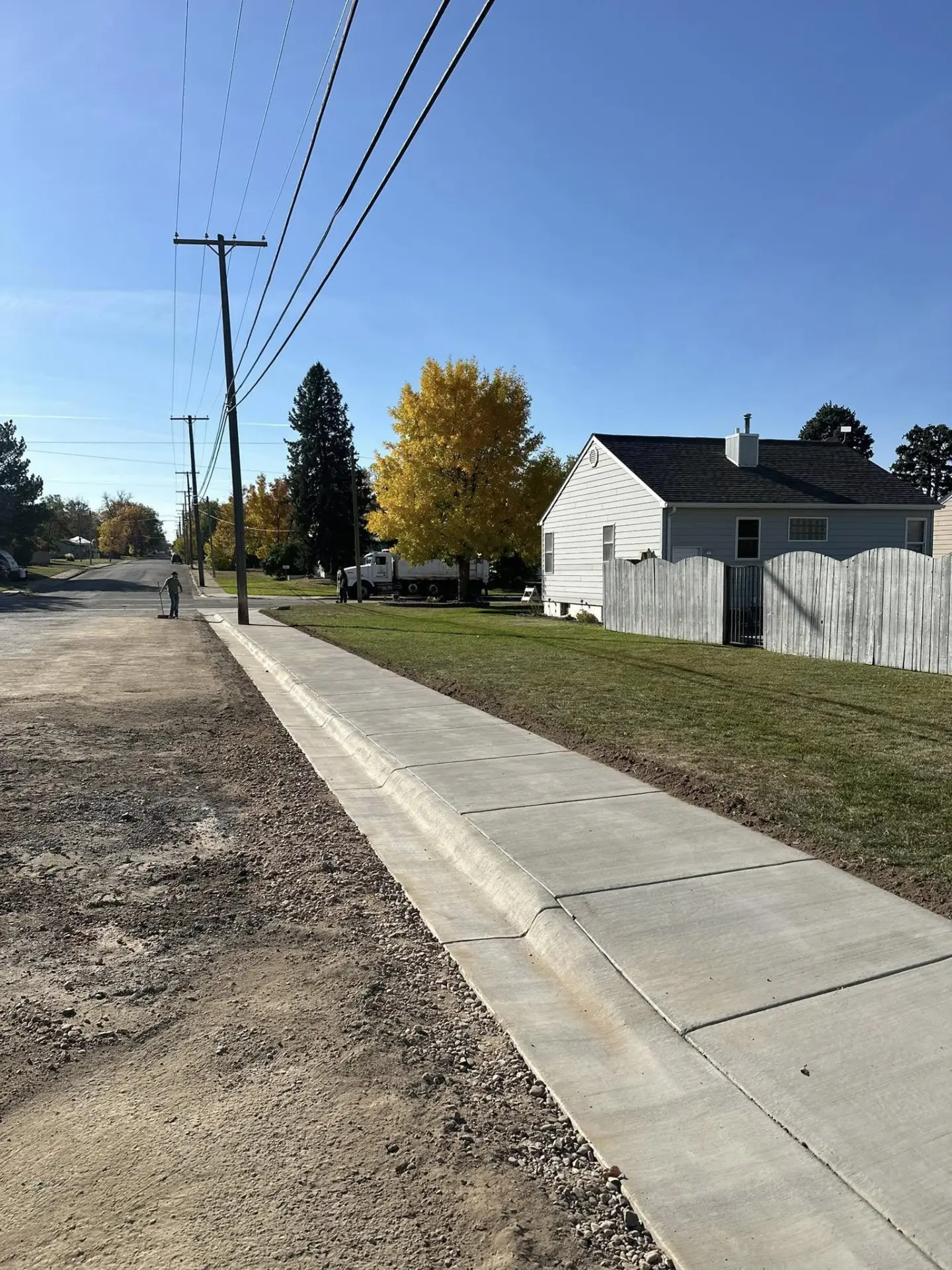 Newly finished concrete sidewalk and curb along a street